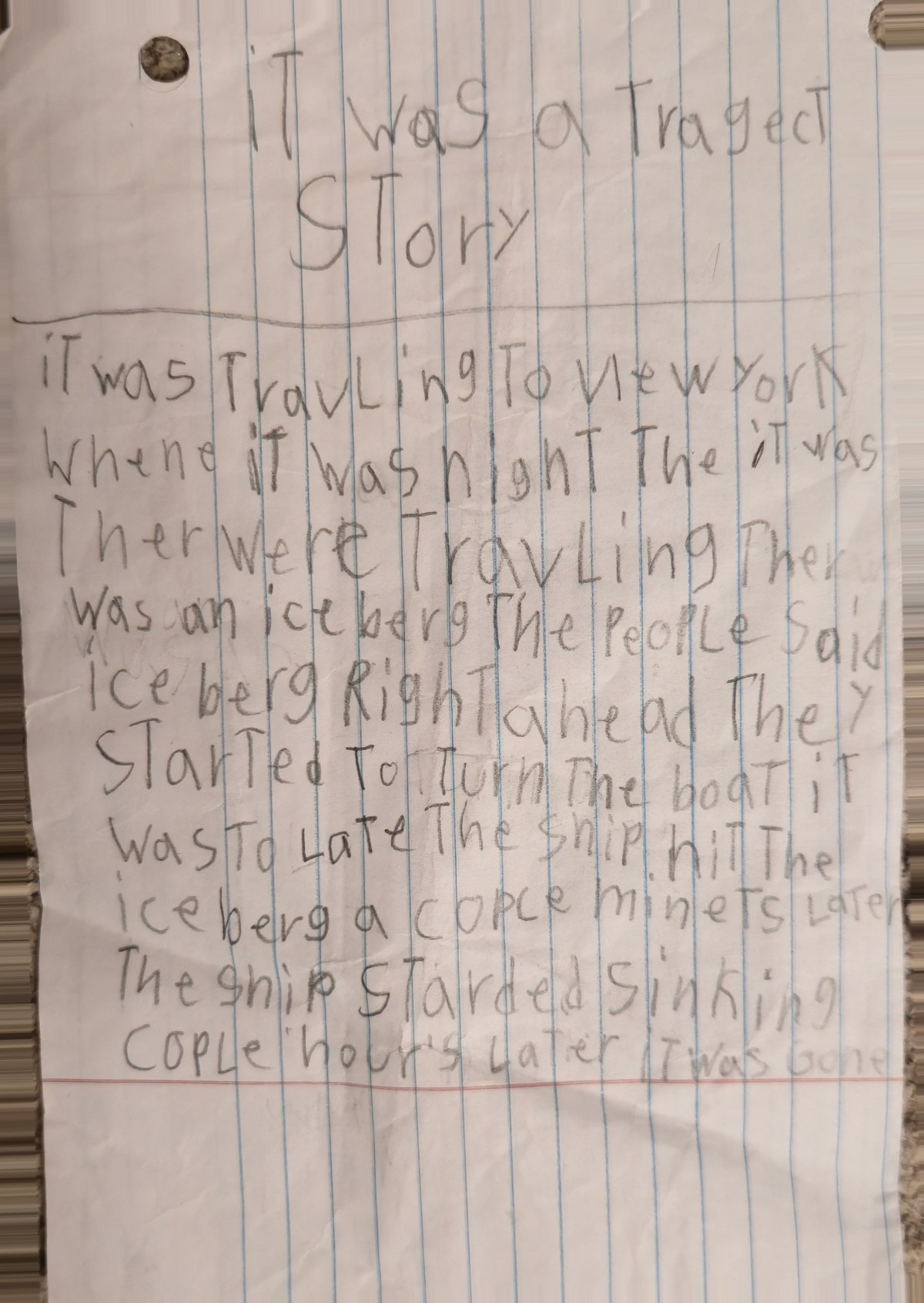 A child's pencil story on ruled paper titled It was a tragect story